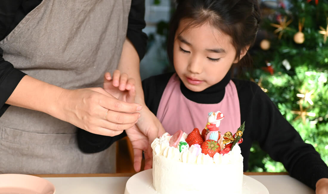 親子でクリスマスケーキ作りを楽しんでいる写真